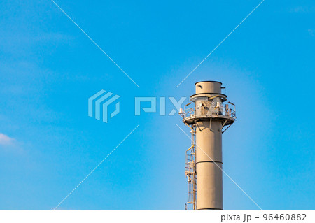Gas flares in petroleum refinery with blue sky background Gas flares in petroleum refinery with blue sky background 96460882