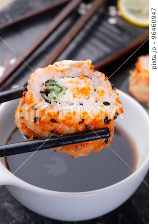 sushi roll holding by sticks. sushi rolls served at grey  tray. flat lay. close up 96460947