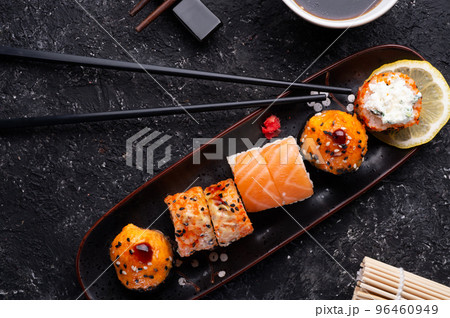 sushi roll set served at black tray with black sticks at black  table. flat lay. 96460949