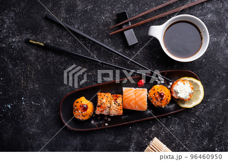sushi roll set served at black tray with black sticks at black table. flat lay. sushi roll set served at black tray with black sticks at black table. flat lay. 96460950