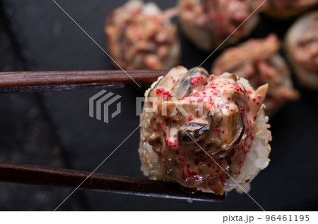 sushi roll  with shiitake mushrooms  holding in sticks served  at black dish at black table. 96461195