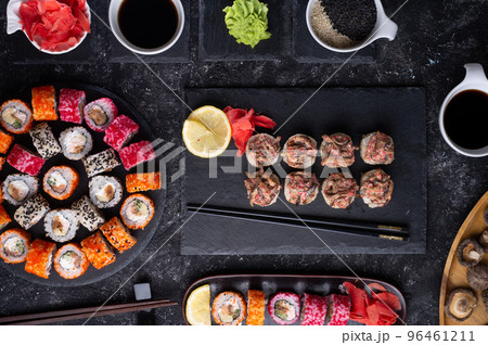 different sushi rolls  with fish and  shiitake mushrooms  served  at black dish with rise at black table. flat lay 96461211