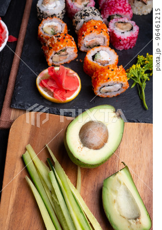 sushi cooking set with rice and ingredients served at black dish at black table. flat lay sushi cooking set with rice and ingredients served at black dish at black table. flat lay 96461215