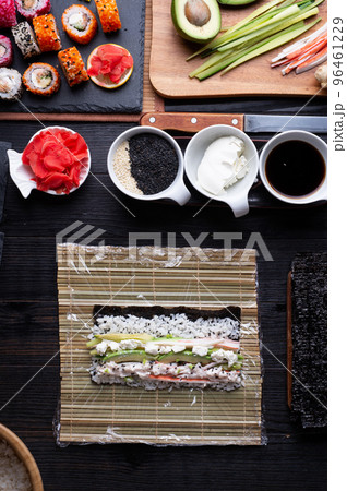 sushi cooking set with rice and ingredients served at black dish at black table. flat lay 96461229