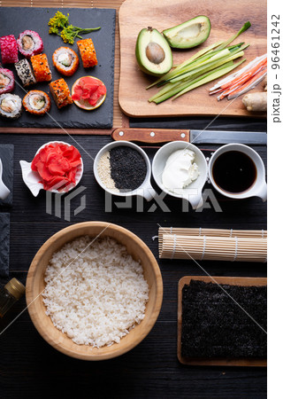 sushi cooking set with rice and ingredients served at black dish at black table. flat lay 96461242