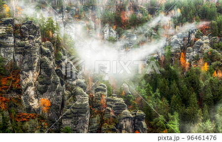 Misty weather in colorful autumn forest and rock formations 96461476