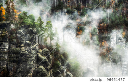 Misty weather in colorful autumn forest and rock formations 96461477