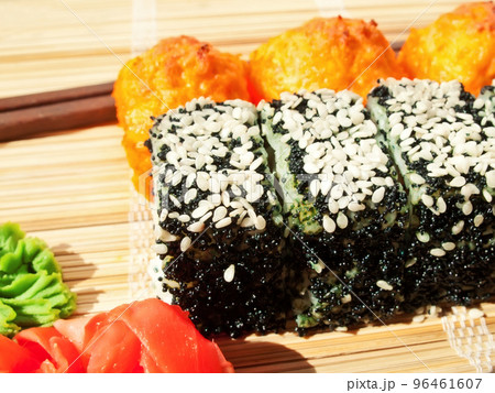 rolls with black roe and sesame and baking sushi on bamboo mat 96461607