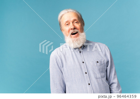 Retired old man with white hair and beard open mouth shiny smile haiving fun excited over blue color background and copy space 96464359