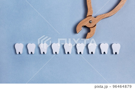 Teeth row with forceps. Surgical tooth extraction or dental implantation. Removal operation. Health care, stomatology concept. Kids toy. Teeth row with forceps. Surgical tooth extraction or dental implantation. Removal operation. Health care, stomatology concept. Kids toy. 96464879