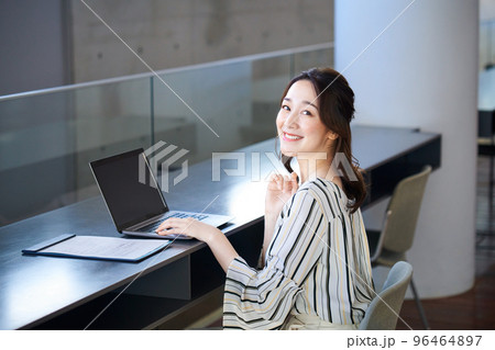 オフィスのカウンターでパソコンを操作するビジネスウーマン 96464897