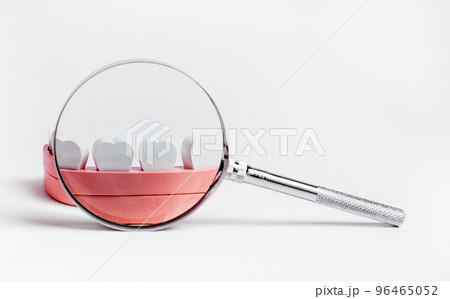 Jaw model with magnifying glass. Kids teeth checkup concept. Dental health problems diagnosis and caries and periodontal disease prevention. 96465052