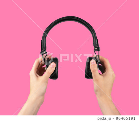 Hands holding wireless headphones on pink background. Audio concept. Accessories for leisure, study. Hands holding wireless headphones on pink background. Audio concept. Accessories for leisure, study. 96465191