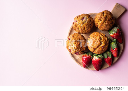 Strawberry muffins on a wooden board on a pink background. 96465294