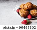 Strawberry muffins with berries served on a plate on a white marble background. 96465302
