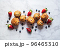 Blueberry and strawberry muffins on a white marble background. 96465310
