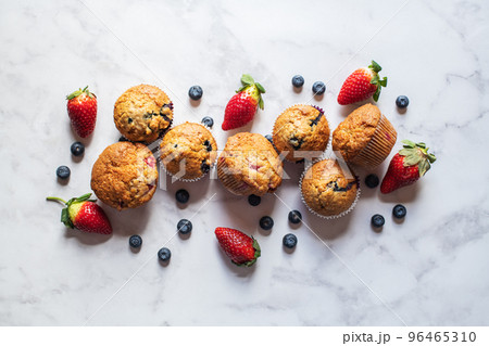 Blueberry and strawberry muffins on a white marble background. Blueberry and strawberry muffins on a white marble background. 96465310