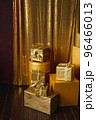 Stack of colorful gift boxes in golden wrapping paper with ribbons 96466013