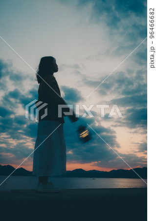 海辺で佇む若い女性のシルエット写真 96466682