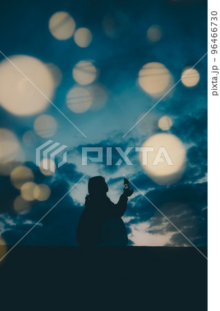 海辺で佇む若い女性のシルエット写真 96466730