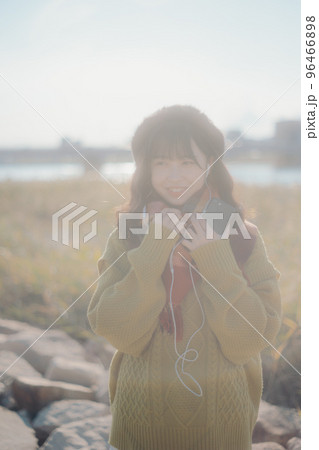 河川敷に音楽を聴きながら佇む若い女性の写真 河川敷に音楽を聴きながら佇む若い女性の写真 96466898