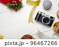Flat lay festive composition with photo camera and colorful Christmas decorations on white wooden background with space for text 96467266