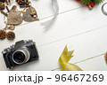 Flat lay festive composition with photo camera and colorful Christmas decorations on white wooden background with space for text 96467269