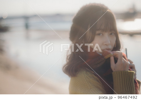 河川敷に音楽を聴きながら佇む若い女性の写真 96467492
