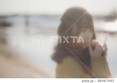 河川敷に音楽を聴きながら佇む若い女性の写真 96467493