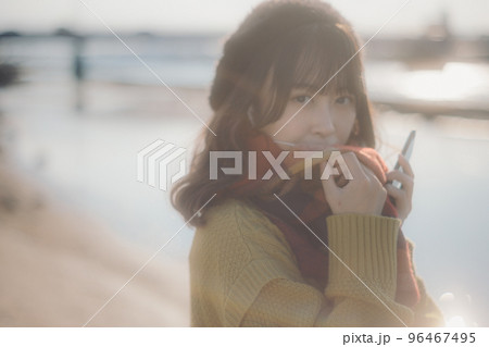 河川敷に音楽を聴きながら佇む若い女性の写真 河川敷に音楽を聴きながら佇む若い女性の写真 96467495