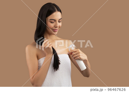 Beautiful long-haired adult woman using hair spray 96467626