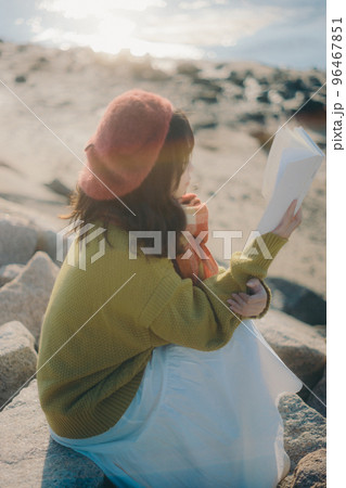 河川敷で本を読みながら佇む若い女性の写真 河川敷で本を読みながら佇む若い女性の写真 96467851