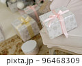 Beautiful Christmas present with silver snowlakes and pink ribbon lying on a chair near christmas tree 96468309