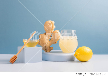 Antioxidant drink fresh ginger lemon honey glass trendy blue background, podium minimalism, balance Antioxidant drink fresh ginger lemon honey glass trendy blue background, podium minimalism, balance 96468469