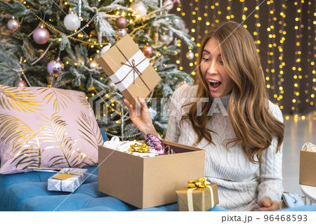 Amazement woman open craft gift box desired present celebrating winter holiday at Christmas tree 96468593
