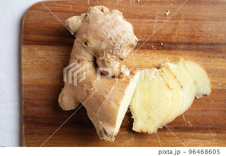 cutting fresh  ginger  spice at wooden desk. Healthy concept. flat lay 96468605