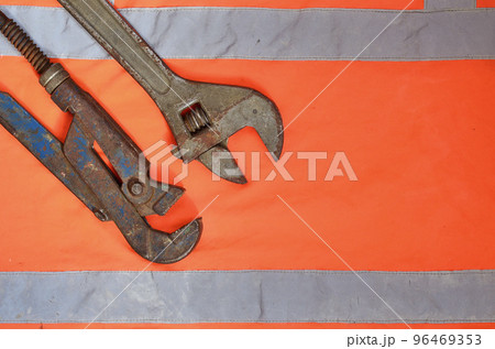 Adjustable and pipe wrenches against the background of an orange 96469353