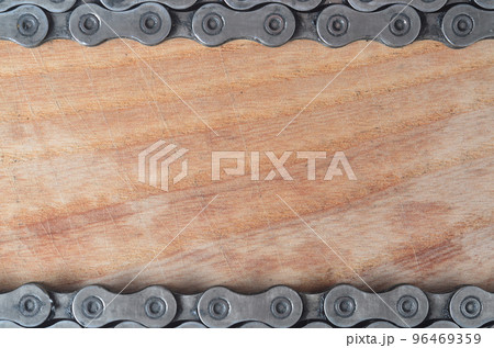 Dirty and oily chain from a mountain bike lying on a wooden table in a bicycle shop 96469359