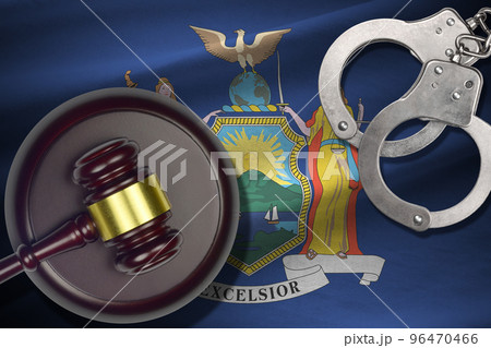 New York US state flag with judge mallet and handcuffs in dark room. Concept of criminal and punishment New York US state flag with judge mallet and handcuffs in dark room. Concept of criminal and punishment 96470466