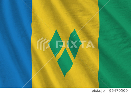 Saint Vincent and the Grenadines flag with big folds waving close up under the studio light indoors. The official symbols and colors in banner Saint Vincent and the Grenadines flag with big folds waving close up under the studio light indoors. The official symbols and colors in banner 96470500