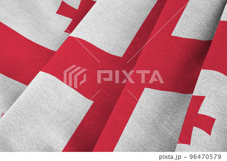 Georgia flag with big folds waving close up under the studio light indoors. The official symbols and colors in banner Georgia flag with big folds waving close up under the studio light indoors. The official symbols and colors in banner 96470579