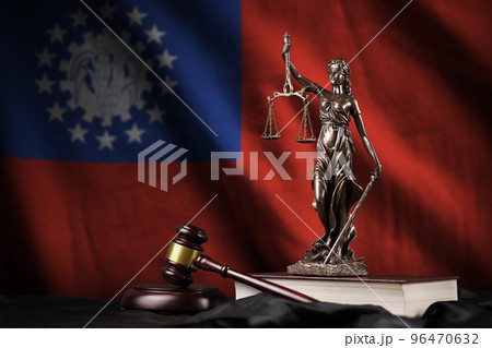 Myanmar flag with statue of lady justice, constitution and judge hammer on black drapery. Concept of judgement and guilt Myanmar flag with statue of lady justice, constitution and judge hammer on black drapery. Concept of judgement and guilt 96470632