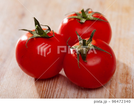Ripe tomatoes on wooden surface 96472340