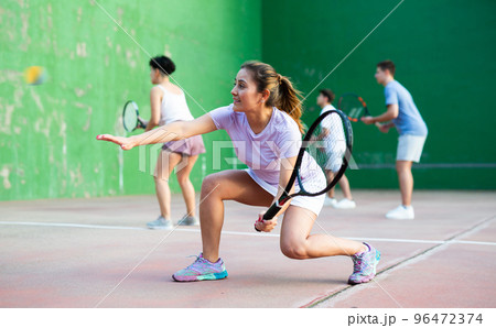Woman playing frontenis with partners at sunny day, healthy lifestyle concept 96472374