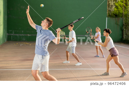 Man playing frontenis with partners at sunny day, healthy lifestyle concept 96472406