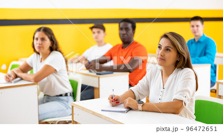 Portrait of focused female studying in classroom with colleagues 96472651