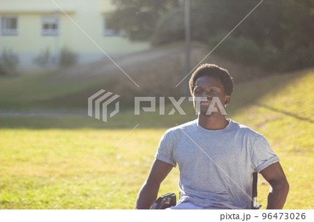 Portrait of happy Black man in wheelchair enjoying sunny weather 96473026