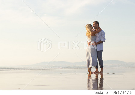 Delighted male and female couple spending time at beach Delighted male and female couple spending time at beach 96473479