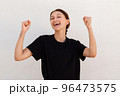 Portrait of joyful young woman celebrating success 96473575