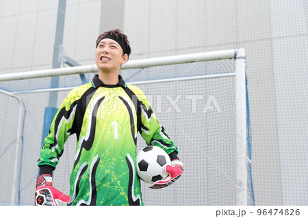 サッカーボールをキャッチするゴールキーパーの男性 96474826